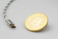 Bitcoin cryptocurrency coin and USB cable on white Royalty Free Stock Photo