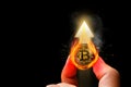 Bitcoin or crypto currency has seen a hot positive increase in price. Holding gold coins in hand with flames with upward arrow Royalty Free Stock Photo