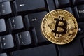 Bitcoin cryptocurrency coin on personal computer keyboard. Close up image. Crypto currency - electronic virtual money for web bank