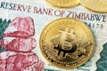 Bitcoin BTC cryptocurrency coins and  Zimbabwe hyperinflation banknote. Africa Bitcoin Royalty Free Stock Photo