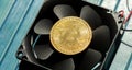 Bitcoin cryptocurrency gold coin symbol laying on top of a desktop PC computer air cooling fan, object closeup. Mining BTC Royalty Free Stock Photo