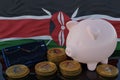 Bitcoin and cryptocurrency investing. Kenya flag in background. Piggy bank, the of saving concept. Mobile application for trading