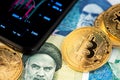 Close up image of Bitcoin with Iranian Rial banknotes Royalty Free Stock Photo