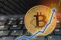 Bitcoin currency rising arrow price record highs on keyboard computer with golden bitcoin and other currencies.