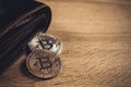 Bitcoin digital currency instead real money, bit-coin with leather wallet or purse on wooden working table, virtual Royalty Free Stock Photo