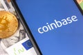 Bitcoin, dollars, euro banknotes and smartphone with Coinbase logo on the screen