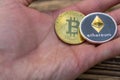 Bitcoin and ethereum lie on mans hand closeup