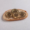 Bitcoin gold coin on bread slice on table