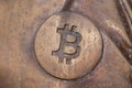 Bitcoin icon on a bronze statue