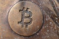 Bitcoin icon on a bronze statue