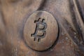 Bitcoin icon on a bronze statue