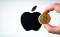 Bitcoin infront of apple logo on white background. To simulate the future of crypto currency,