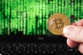 Bitcoin infront of matrix binary codes and laptop. To simulate online crypto currency payment, security and hacking