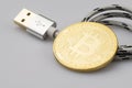 Bitcoin leaning on USB cable isolated on white background Royalty Free Stock Photo