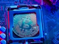 Bitcoin lies on the processor of a personal computer. Illuminated with neon light. Computer components, cryptocurrency, bitcoin,