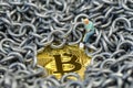 Bitcoin mining by miniature figure holding shovel digging on shiny golden physical Bitcoin Crpto currency coin surround by metal