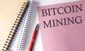 BITCOIN MINING word on the pink paper with office tools on white background Royalty Free Stock Photo