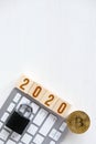 Bitcoin with numbers 2020 on cubes on a white keyboard wooden background a lock. Cryptocurrency security concept in the new year. Royalty Free Stock Photo