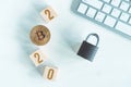 Bitcoin with numbers 2020 on cubes on a white wooden background with a keyboard and a lock. Cryptocurrency security concept in the Royalty Free Stock Photo