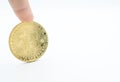 Someone finger with golden Bitcoin isolated on white background.