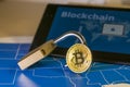 Bitcoin and open padlock over a US map and a screen with blockchain word