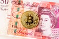 Bitcoin and 50 pound banknotes Royalty Free Stock Photo