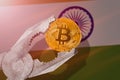 Bitcoin regulation in India; bitcoin btc coin being squeezed in vice on India flag background Royalty Free Stock Photo