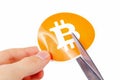 Bitcoin symbol being cut in half with scissors held in human hand, fall of digital currency Bitcoin prices, halving Royalty Free Stock Photo