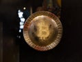 Bitcoin Symbol on a Round Golden Emblem Surrounded by Zeroes and Ones