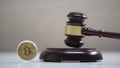 Bitcoin on table, gavel striking on sound block, crypto currency legalization