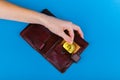 Bitcoin theft concept. A hand steals bitcoin from a wallet. Place for writing Royalty Free Stock Photo