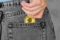 Ethereum in a woman`s hand. A woman`s hand puts Ethereum in the back pocket of her jeans