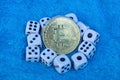 Bitcoin yellow coin and white game dice on blue wool