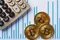 Bitcoins and caculator on chart as financial concept Royalty Free Stock Photo