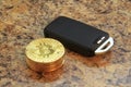 bitcoins cryptocurency with car key on granite table Royalty Free Stock Photo