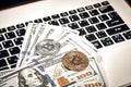 Bitcoins with dollar bills on laptop keyboard. Royalty Free Stock Photo