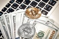 Bitcoins with dollar bills on laptop keyboard. Royalty Free Stock Photo