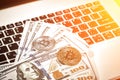 Bitcoins with dollar bills on laptop keyboard. Sun flare Royalty Free Stock Photo