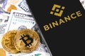 Bitcoins, dollars with Binance logo on the screen smartphone