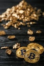 Bitcoins and gold nuggets on dark wooden background Royalty Free Stock Photo