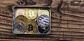 Bitcoins, litecoin and ethereum lies in metal box on old wooden background Royalty Free Stock Photo