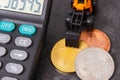Bitcoins, miniature excavator and calculator, cryptocurrency and international network payment concept Royalty Free Stock Photo