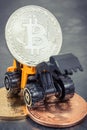 Bitcoins and miniature excavator. Cryptocurrency and international network payment. Finance concept