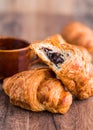 Bite chocolate croissant with a cup of coffee, french baking