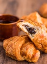 Bite chocolate croissant with a cup of coffee, french baking