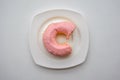 Bite donut ring with strawberry flavor glaze frosting on white p Royalty Free Stock Photo