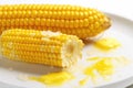 bite marks on a butter glazed sweet corn on a white plate