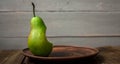 A bite pear on a plate on wooden background Royalty Free Stock Photo