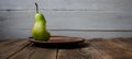 A bite pear on a plate on wooden background Royalty Free Stock Photo