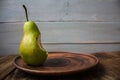 A bite pear on a plate on wooden background Royalty Free Stock Photo